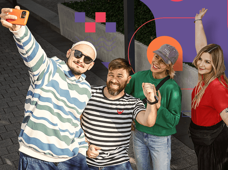 Czworo młodych ludzi pozuje do selfie na ulicy, uśmiechnięci, ubrani w casualowe i kolorowe ubrania