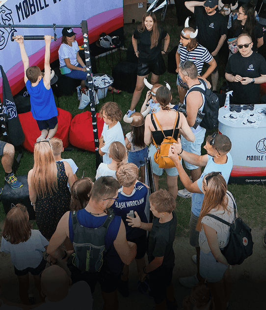 A group of people gather at a Mobile Vikings stand during an outdoor event