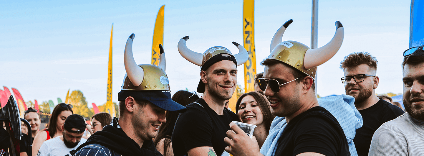 Grupa osób w hełmach Vikingów bawi się podczas plenerowego wydarzenia
