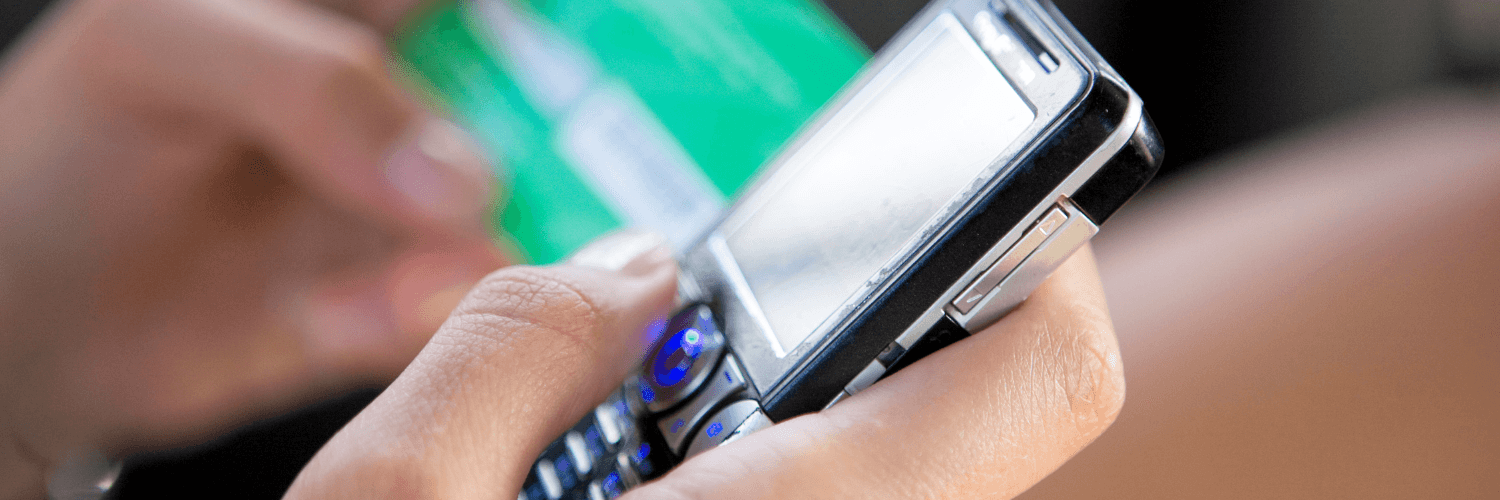 Osoba wstukuje na telefonie numer karty prepaid