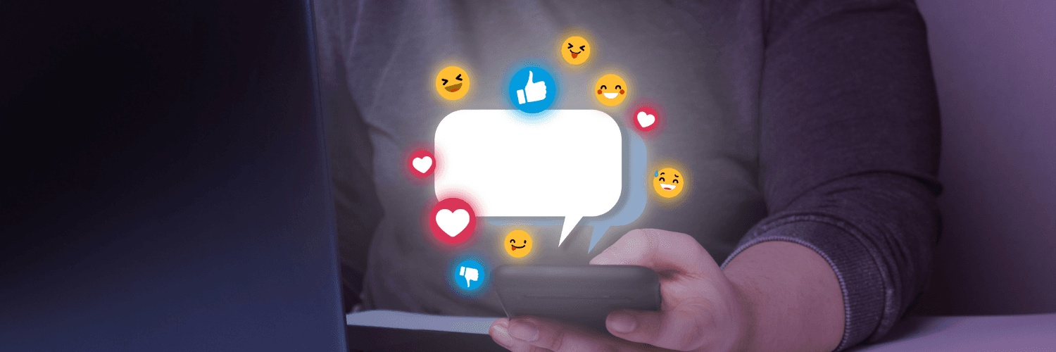 Z telefonu trzymanego w dłoni wyskakują emotikonki i wiadomość sms