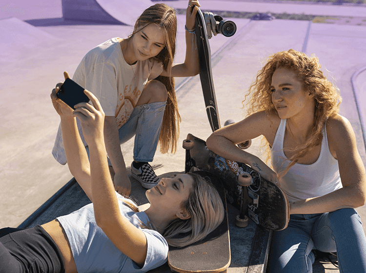kobiety w skateparku, patrzące w telefon