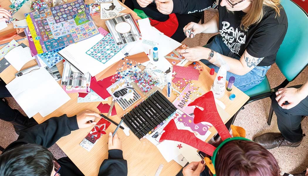 Grupa osób wycina papierowe zakładki do książek