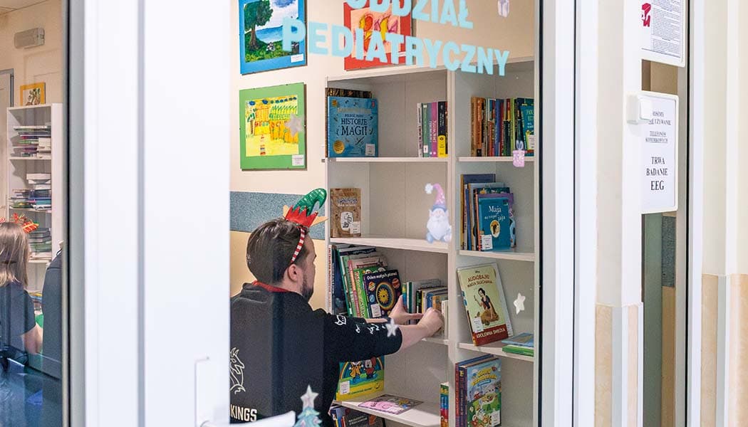 Mężczyzna układa książki na półce