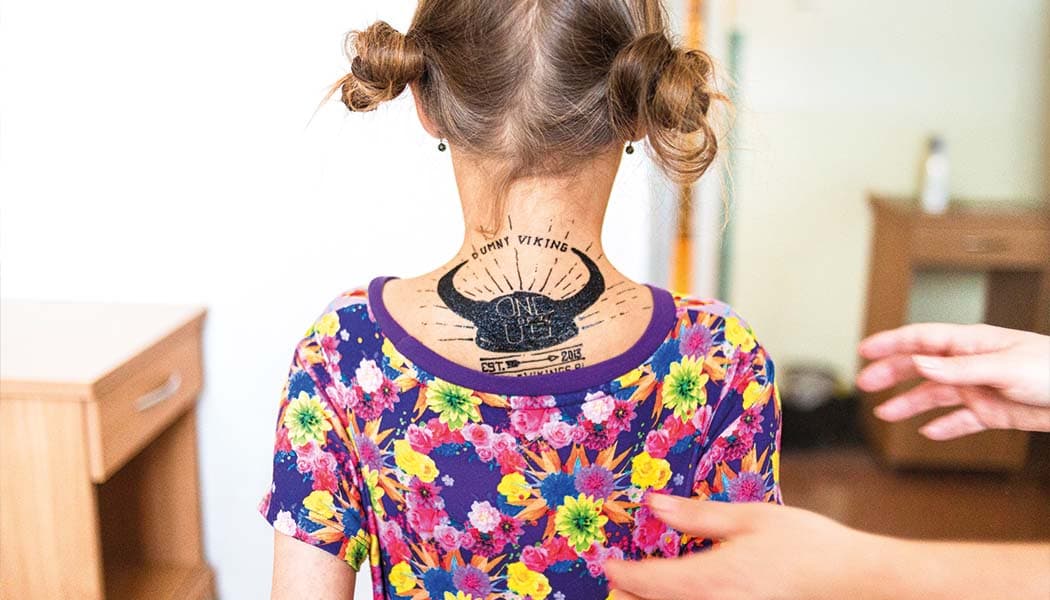 Dziewczynka z tatuażem Mobile Vikings na karku