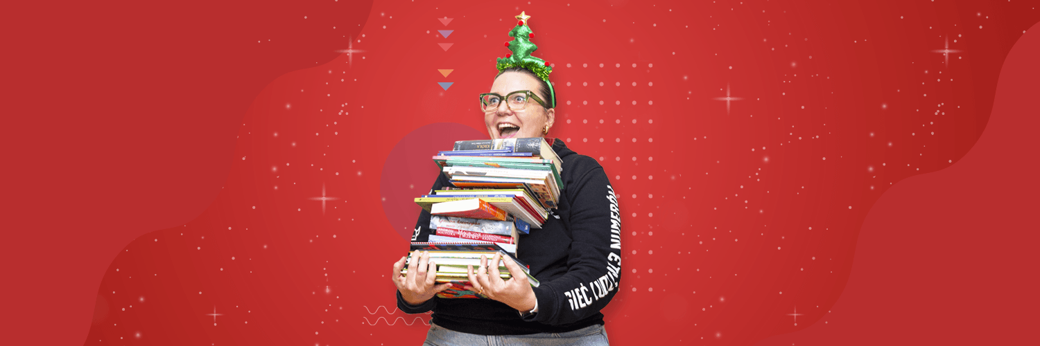 Kobieta z choinką na głowie trzyma stos książek