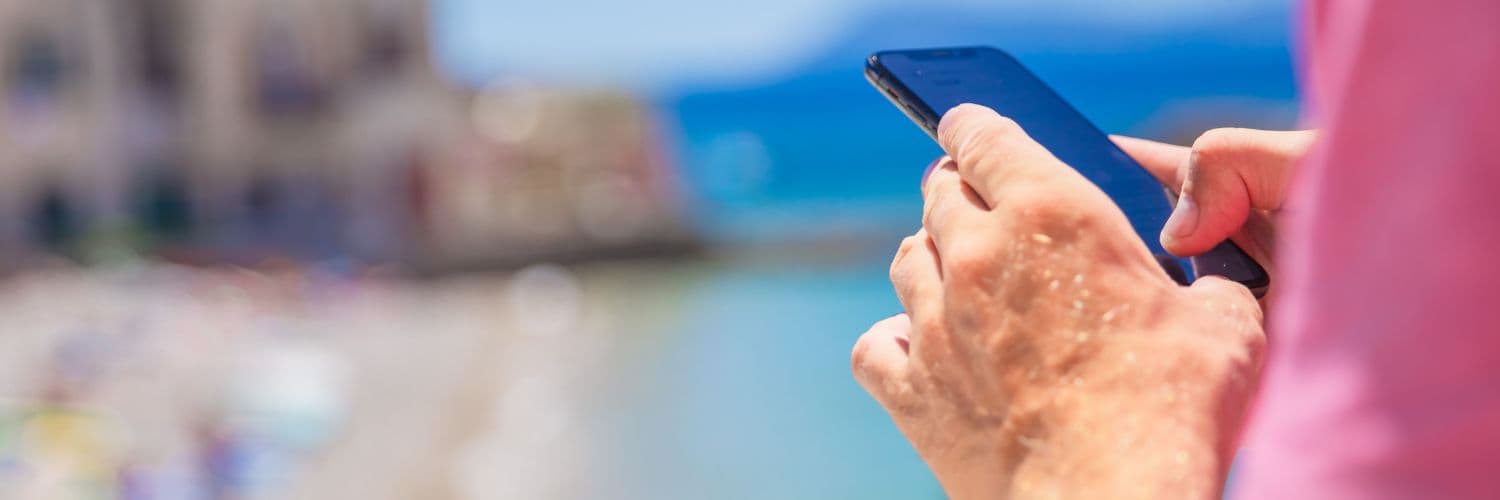 męska dłoń i telefon na wakacjach – bohater sprawdza limit danych w roamingu